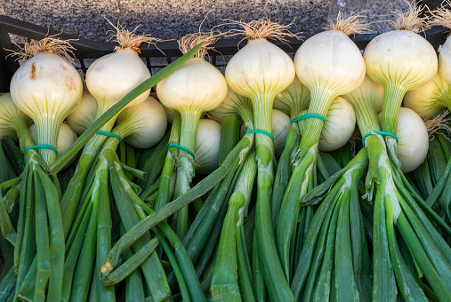 Green onion isolated for sale, from local gardens, in a street market. Healthy and organic food.