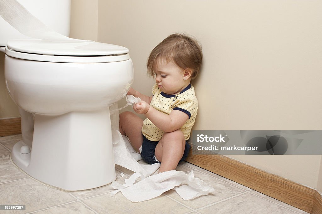 Toddler ripping up toilet paper Toddler ripping up toilet paper in bathroom Baby - Human Age Stock Photo