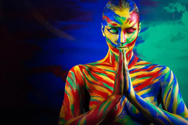 Color art face and body paint of woman for inspiration. Abstract portrait of the bright beautiful girl with colorful make-up and bodyart.
