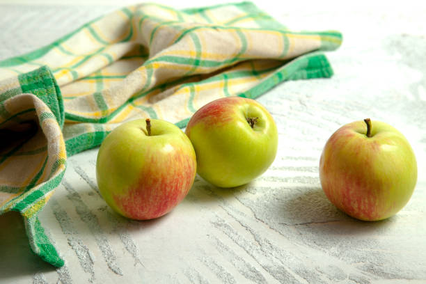 istock Three green apples on white wooden background. 1840013164