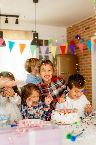 Children get excited with confetti on a indoor Birthday celebration