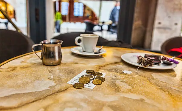 Few coins and the bill on a coffee table after the clients have left.