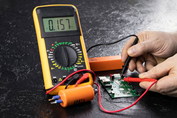 istock An electrician takes readings from a microcircuit using a multimeter. Measuring instruments. Copy space. Voltage measuring tool. Checking battery voltage. Male hands repairing a microcircuit. 1840068828