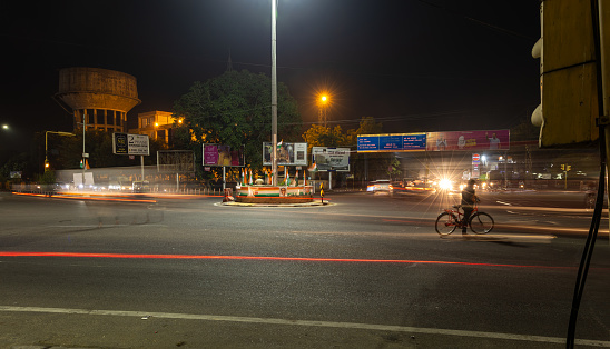 city street traffic long exposure shot with blurred light trails with at traffic control signal image is taken at sardar market ghantaGhar jodhpur rajasthan india on Nov 06 2023.