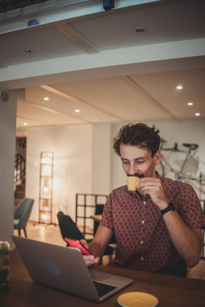 istock A young hipster man is sitting in a cafe drinking coffee and using a mobile phone to surf the internet or send messages 1840103366