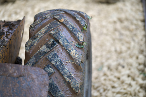 A digger truck rubber tyre with deep treads resting on a sand stone track, road, under construction