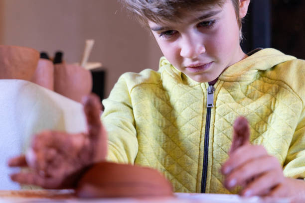 istock Concentrated boy learning to use the potter's wheel 1840115455