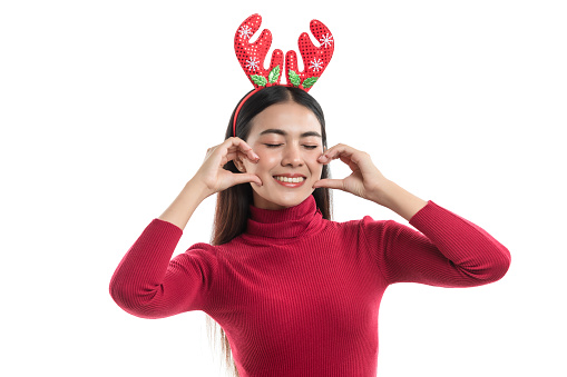 Portrait of smiling young woman long hair wearing red sweater with reindeer horns headband good mood isolated over white background.