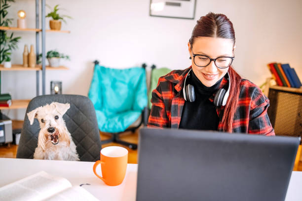 istock Young woman working from while home spending time with her dog 1840150456