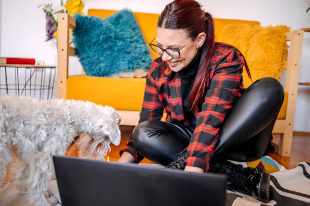 istock Young woman working from while home spending time with her dog 1840151010