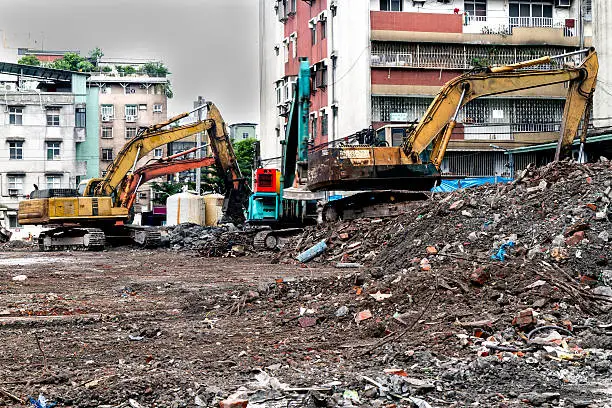 Construction site with rubble and trucks demolishing