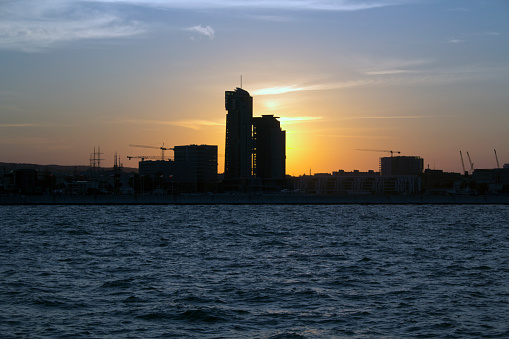 Gdynia, Poland, sunset over the city. The silhouette of the city seen from the sea during sunset.