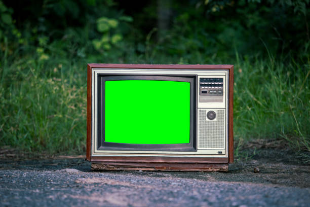 Retro old TV with chroma key green screen for designer in forest background.
