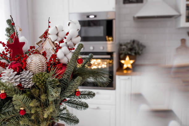 istock A spruce bouquet with red berries, toys, cotton on a white kitchen table. Christmas decorations in the interior. The concept of preparation for the New Year's holiday 2024. 1840190657