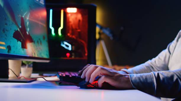 istock Man using gaming RGB lit mouse to shoot asteroids in spaceship flying videogame 1840255540