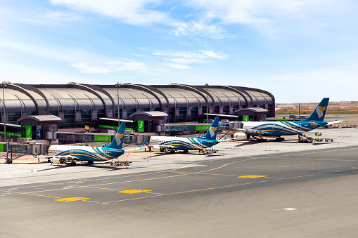 Muscat, Oman - May 28, 2023: Oman Air planes at the boarding gates of the airport in Muscat. Sultanate of Oman