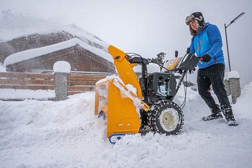 Snow Removal Equipment. Clearing snow from access road using a snow blower.