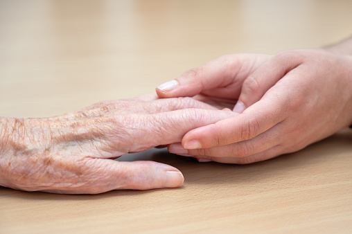 Hands of a young and old woman are holding together. High quality photo