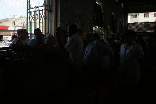 Stone Town, Zanzibar, Tanzania - November 27, 2015: A group of local men crowd round a shop to read the newspapers in Zanzibar's capital. Nobody actually buys the paper, they just all read it from a distance. 