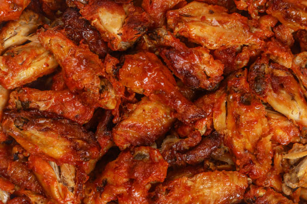 Roasted buffalo chicken wings in baking tray.