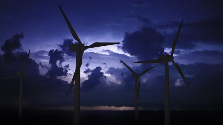 Thunderstorm over wind farm. Renewable energy concept. Wind turbines with lightning and storm