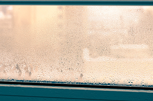 Greenhouse effect. Drops of condensation on a metal-plastic window.