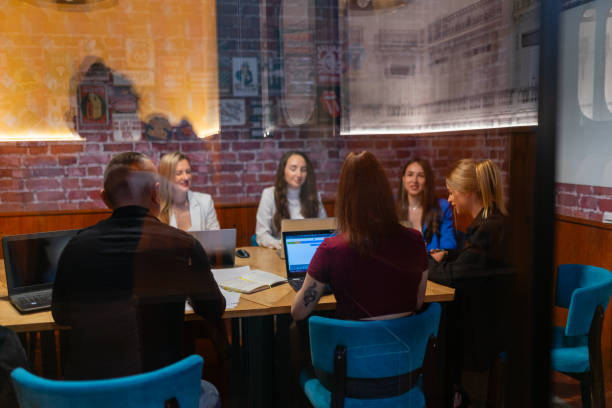 istock Videographer films employees of modern office through glass 1840331889