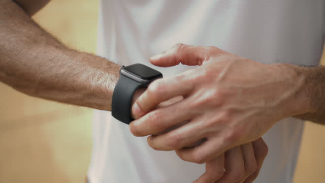 Hands touching smart watch close up. Athlete check performance data on display