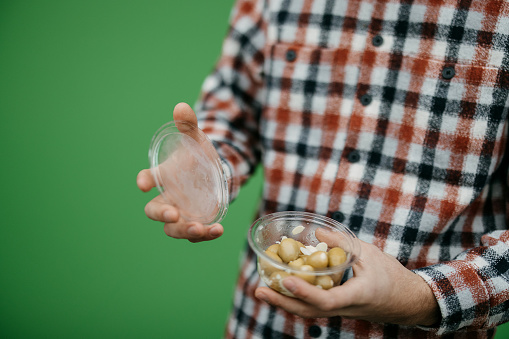 Man holding olives in a plastic container