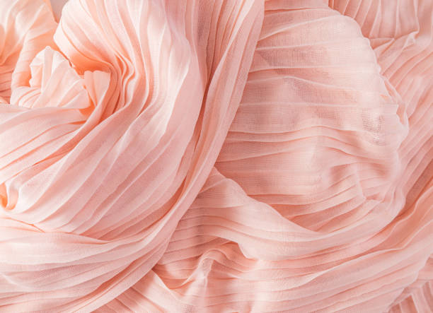istock Delicate air waves of peach-colored silk or chiffon fabric. Layout for design. Background image for holiday decor. color trend 2024 peach color. 1840352356