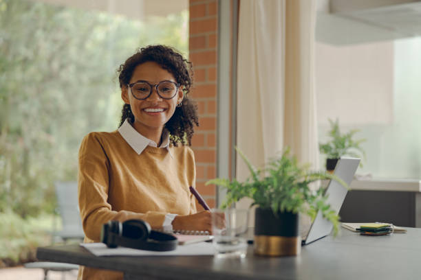 istock Female freelancer working laptop remotely and making notes sitting at home. Distance work concept 1840352480