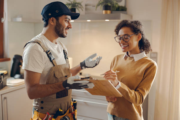 istock Smilng young woman signing document while communicating with handyman at the kitchen 1840352854