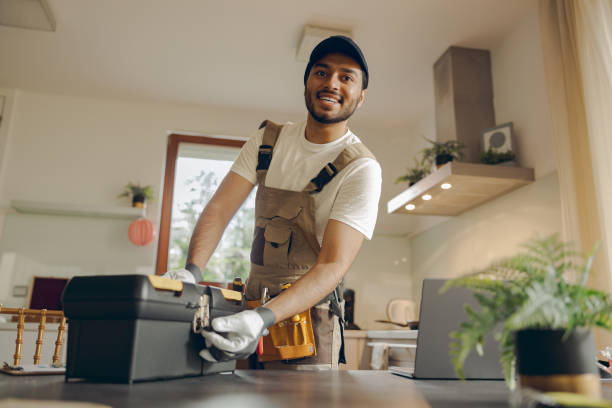 istock Professional repairman in uniform standing on home kitchen and opening his tool bag 1840352925