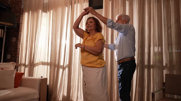 Happy senior couple dancing at home