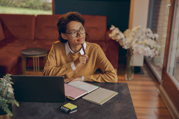 istock Female freelancer working laptop remotely and making notes sitting at home. Distance work concept 1840359854