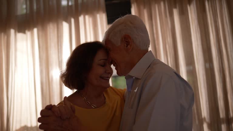 Happy senior couple dancing at home