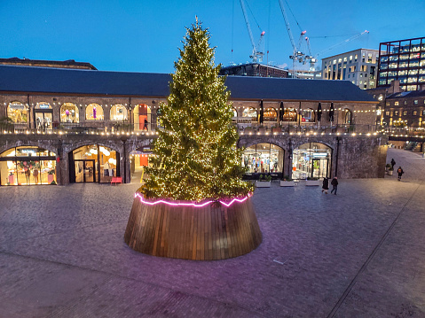 christmas decorative tree by coal drops yard shopping center near regent's canal during night at london england UK