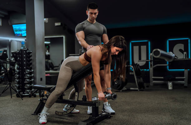 istock Personal trainer working with his client in the gym 1840409703