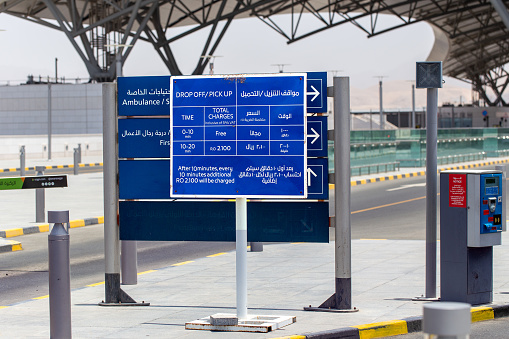 Muscat, Oman - May 28, 2023: Stand at entrance to Muscat Airport informing motorists about free 10 minutes of parking for disembarking and picking up passengers