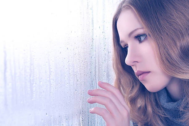 печаль девочка у окна в дождь - beautiful boredom sensuality desire стоковые фото и изображения