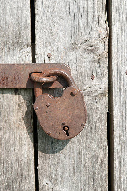 istock Old rusty padlock on a wooden door 184042274