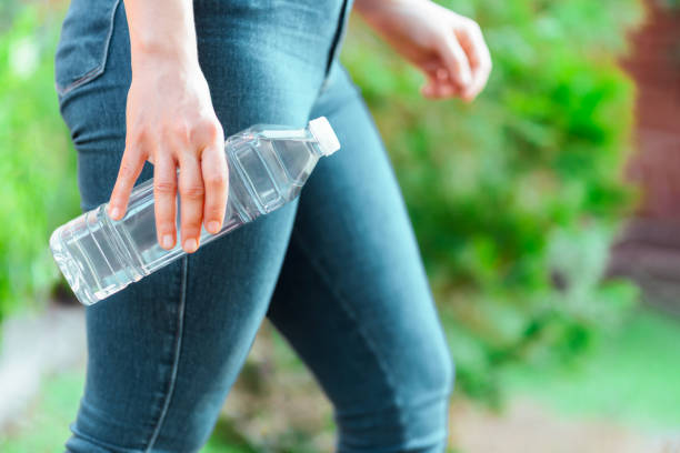 istock Bottle of water with green trees background 1840425405