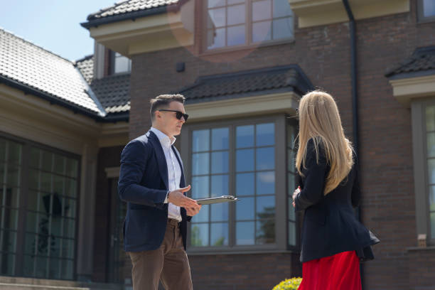 istock Property agent demonstrates expensive suburban house 1840428549