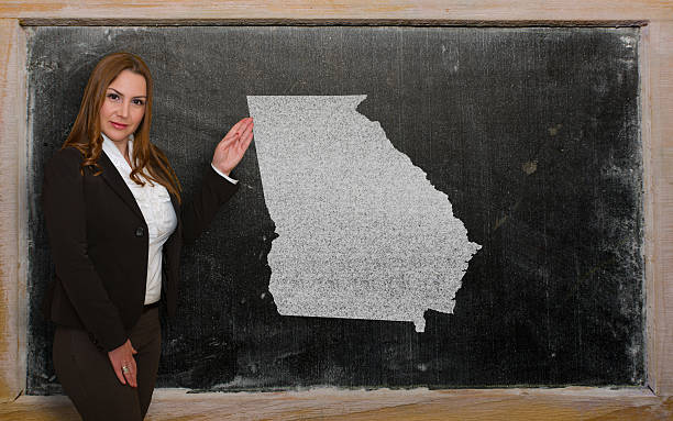 Teacher showing map of georgia on blackboard Successful, beautiful and confident young woman showing map of georgia on blackboard for presentation, marketing research and tourist advertising georgia us state photos stock pictures, royalty-free photos & images