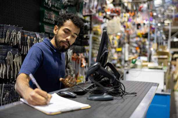 mężczyzna pracujący w sklepie z narzędziami i piszący notatki na ladzie - clipboard men sales occupation casual zdjęcia i obrazy z banku zdjęć