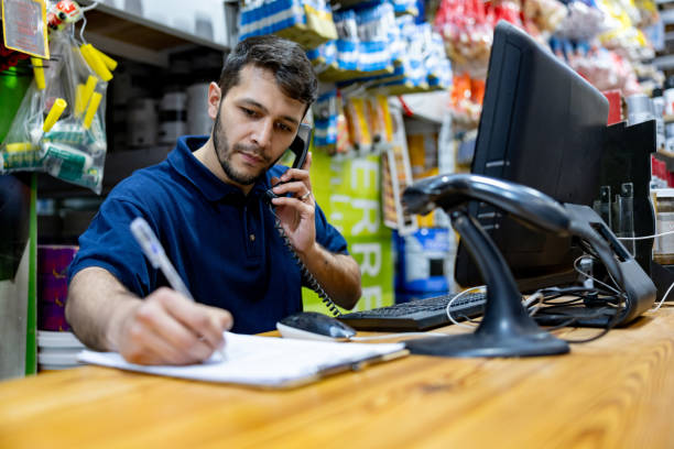 sprzedawca pracujący w sklepie z narzędziami przyjmuje zamówienie przez telefon - clipboard men sales occupation casual zdjęcia i obrazy z banku zdjęć