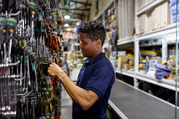 istock Happy salesman working at a hardware store and searching for a wrench 1840468477