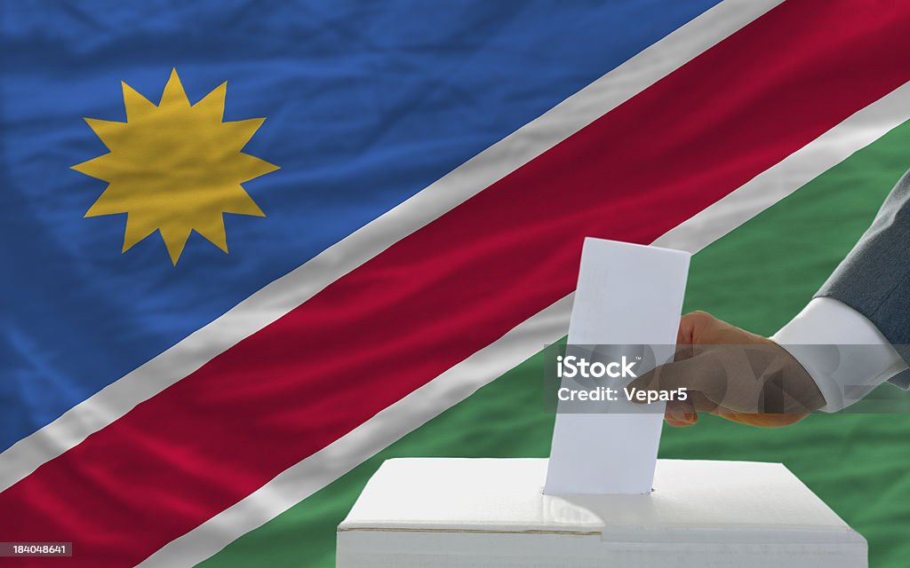 Hombre de voto en las elecciones en namibia front of flag - Foto de stock de Bandera libre de derechos