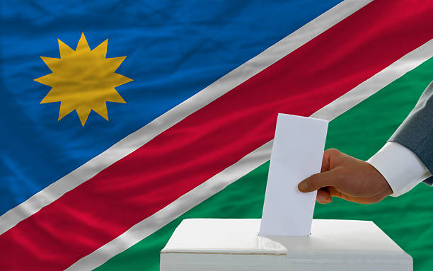 man voting on elections in namibia front of flag stock photo