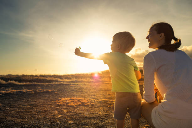 istock Mother and son watching beautiful sunset in Hawaii. 1840515832